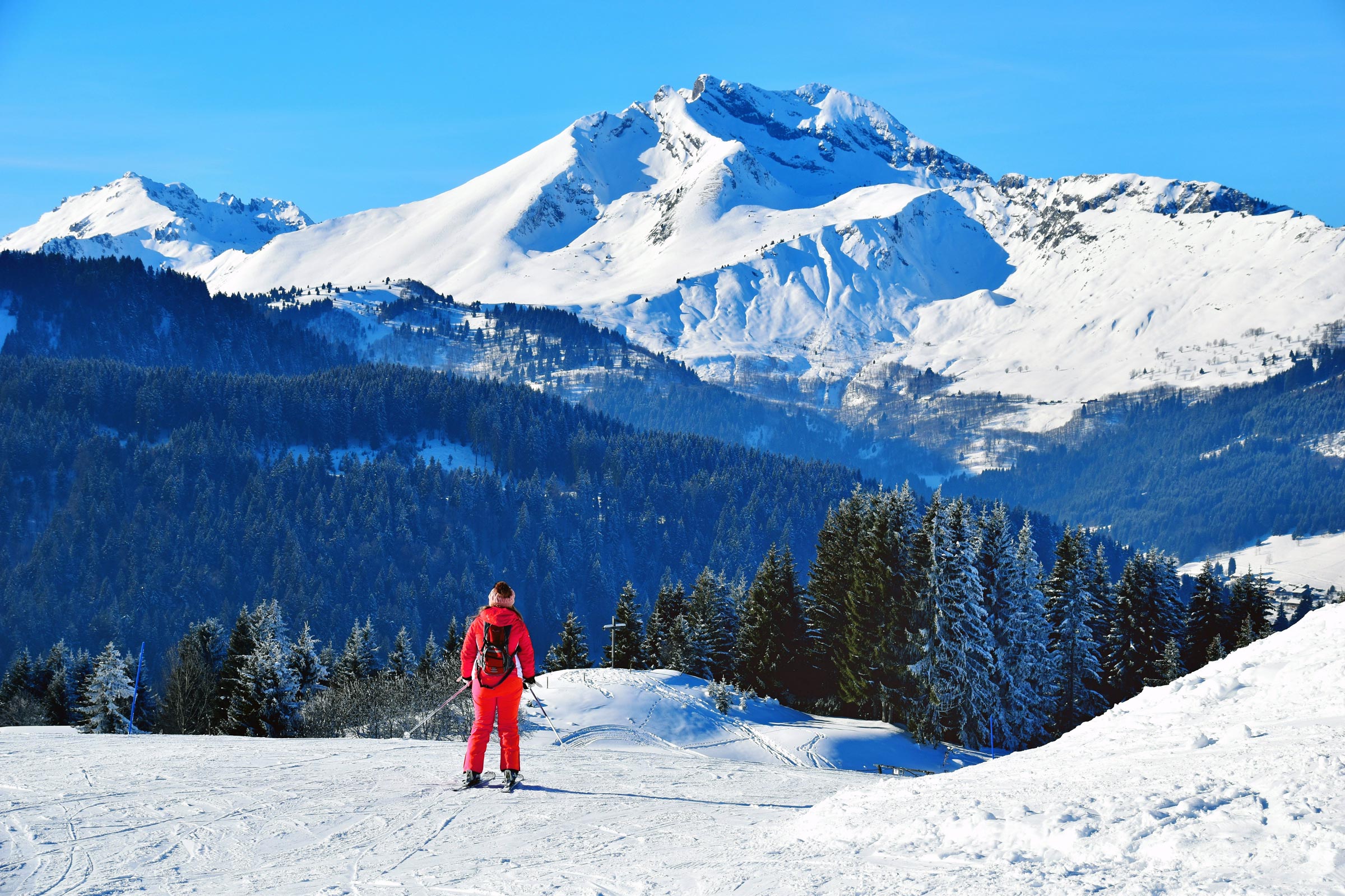 Mountain vista near Morzine in the French Alps, featuring a single skier wearing red.