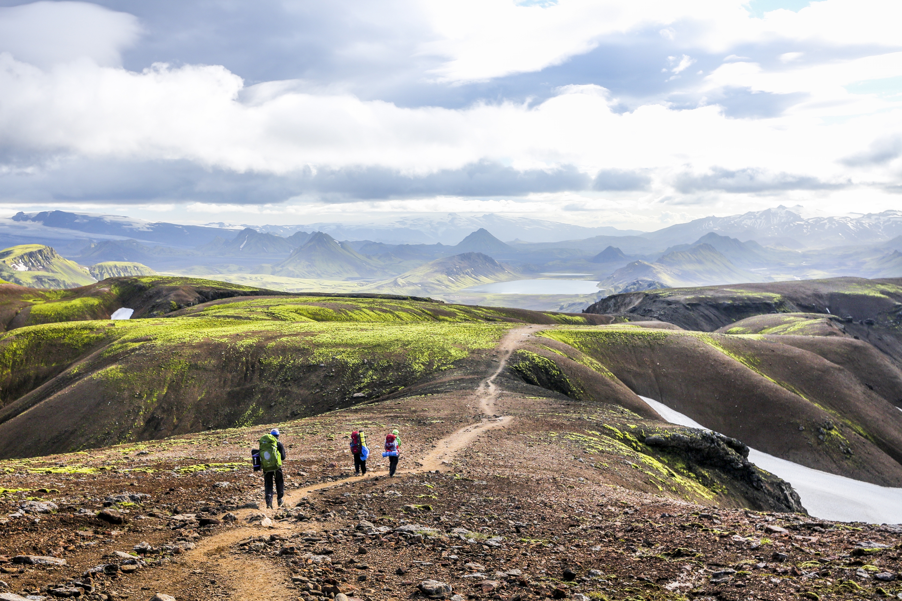 Hiking in the incredible wild landscape of green mountains, among glaciers and volcanoes in Iceland